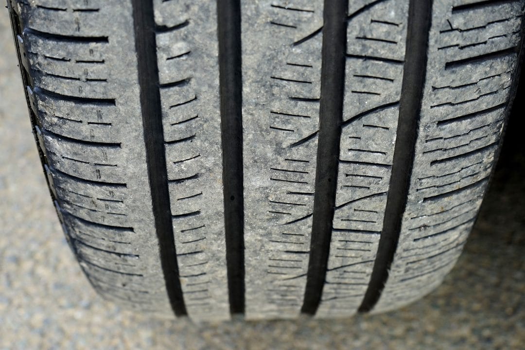 Neumático de coche con el dibujo desgastado, un detalle que hay que revisar antes de un viaje largo en verano